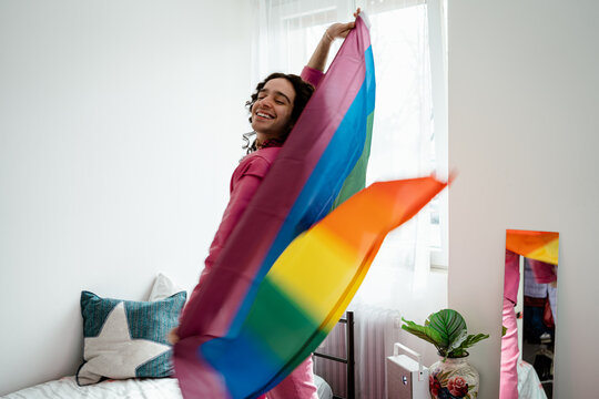 Man playing with an lgbt rainbow flag at home