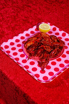 pink tray patterned with red dots with some cooked crayfish