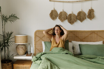 Happy woman waking up in cozy bedroom