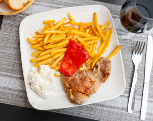 Tasty pork with boiled potatoes and stewed peppers