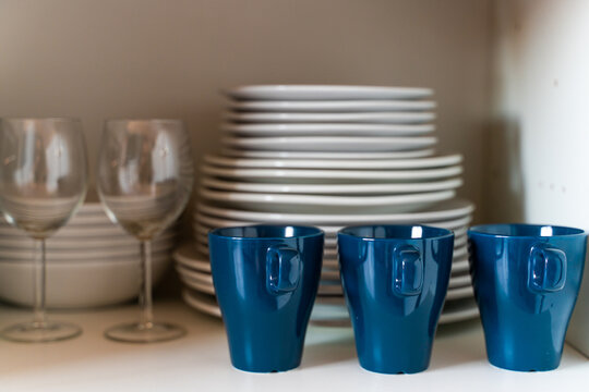 Kitchenware. Glasses and dishes in kitchen cupboard