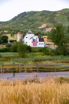Vertical Image Park City Utah Barn farm landscape with American Flag 