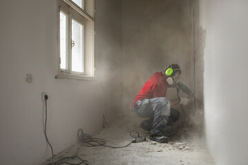 Construction worker working on the old interior wall
