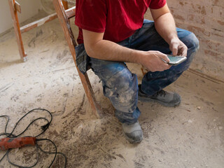 A construction worker is using a phone app