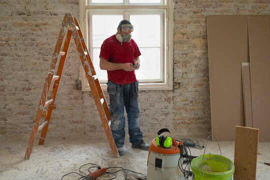 A construction worker is using a phone app