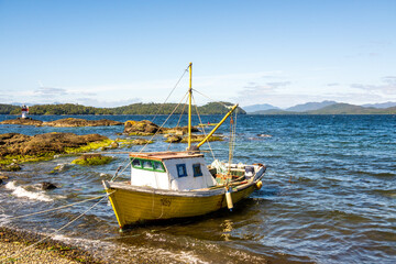  a small artisanal subsistence fishing boat on a beach in patagonia chile. room for text	