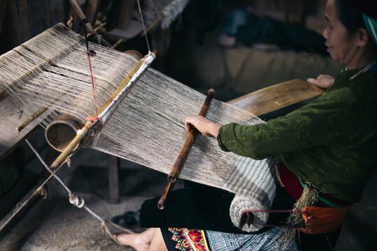 Traditional production: weaver woman working with a loom in a workshop