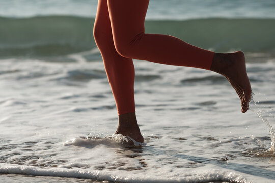 Anonymous woman running on the seashore