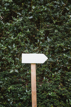White handmade wooden sign pointing to the right