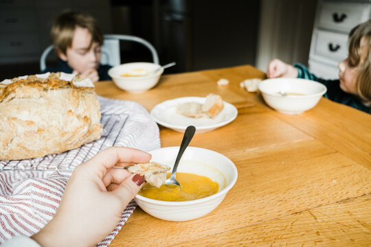 ugc pov photo of hand dipping bread into healthy soup