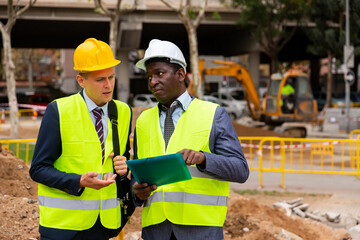 Engineer and architect discusses construction plan at the construction site outdoor
