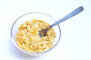 Mashed bananas in bowl on white background.