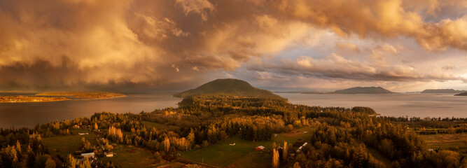 Beautiful Island Sunset With Dramatic Storm Clouds Across the Salish Sea Area of the Pacific Northwest. Aerial panoramic view of Lummi Island, Washington just after a spring rain shower.