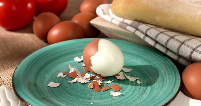 peeled egg on a plate. boiled chicken eggs with bread and tomatoes. fresh eggs on the table. farm product closeup. natural healthy food. breakfast ingredients. rustic still life on a sunny day.