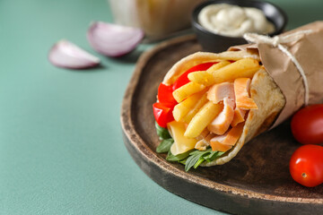 Delicious pita wrap with chicken, french fries and pepper on light blue background, closeup. Space for text