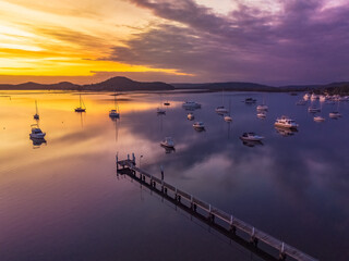 Aerial sunrise waterscape with boats and high cloud