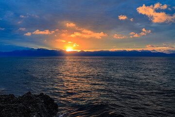 The golden radiant sunrise is on top of the mountain and on the scenic bay, vast...