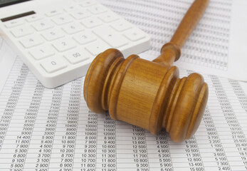 Close-up of judge gavel, calculator and financial documents.