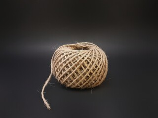 A roll of brown small hemp rope burlap straw rope coir fiber rope isolated on black background