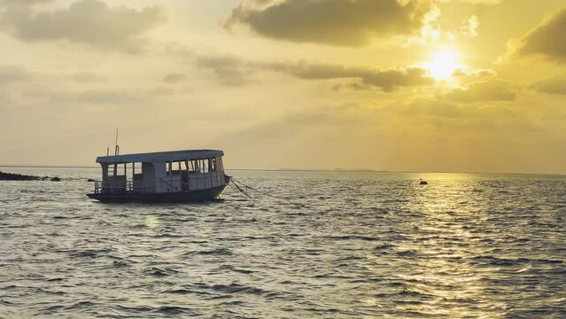 Sunset View in Maldives: Ocean view and Serene Stillness of the Island's Dusk Skyline, with a Traditional Dhoni Boat Drifting Along the Horizon, Perfect Tropical Getaway Experience