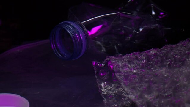 Empty Clear Plastic Bottle And Lid On The Table With Bubble Wrap, Black Plastic For Packaging, And Pieces Of Caplet Pills. closeup, pullback