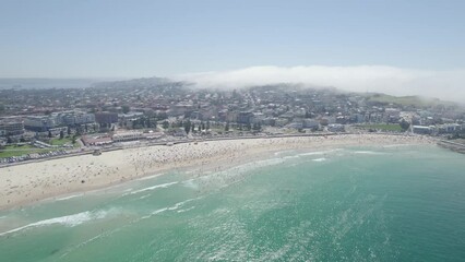 Jam-packed Bondi Beach In Sydney, Australia With Crowds Of Sunbathers And Swimmers In Summer. aerial pullback
