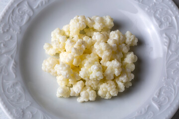 Kefir fermented milk drink with kefir grains. Homemade kefir stands in a glass, next to kefir grains and milk