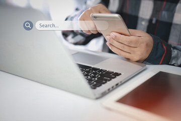 Smart male hands using laptop computer keyboard and smartphone searching, browsing internet data online information with search bar console interactive on screen. Lifestyle with technology