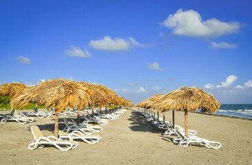 Beach with umbrella and chairs in a sunny day