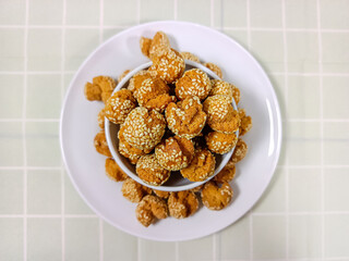 Top view of Onde-onde Ketawa, Indonesian version of dried Sesame Ball on a white plate. Overhead shot of dried Onde-onde. Originated from China, called Jiandui. This is famous snacks in Indonesia.