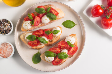Tomato, basil and mozzarella cheese fresh made caprese bruschetta. Italian tapas, antipasti with vegetables, herbs and oil on grilled ciabatta and baguette bread. Open sandwich.