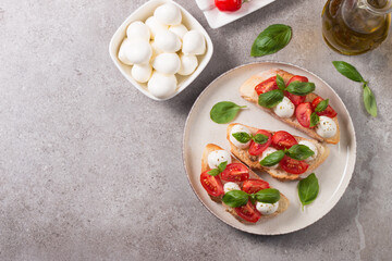 Tomato, basil and mozzarella cheese fresh made caprese bruschetta. Italian tapas, antipasti with vegetables, herbs and oil on grilled ciabatta and baguette bread. Open sandwich.