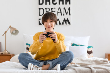 Teenage boy playing video game in bedroom © Pixel-Shot