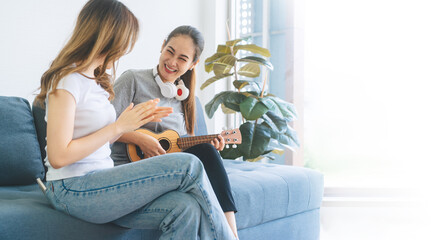 Southeast asian people couple relax lifestyle playing music on sofa life moments at home