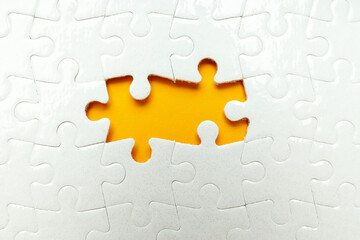Fototapeta premium White puzzles without two puzzles on orange background