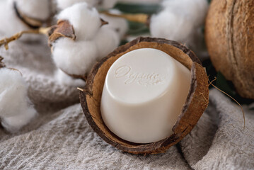 Fototapeta na wymiar A piece of white natural soap with the inscription Organic from a coconut shell soap dish
