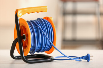 Extension electric cable reel on table