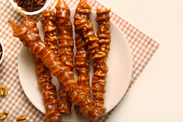 Plate with tasty churchkhela on light background, closeup