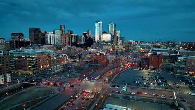 Cinematic twilight aerial over Speer Boulevard with traffic, Denver skyline view