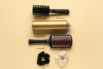 Bottle of hair spray, brushes, scrunchies and pins on color background