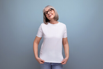 Fototapeta premium a mature woman of retirement age is in menopause in a white tank top on a studio background