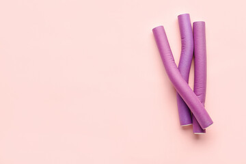 Hair curlers on pink background