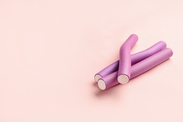 Hair curlers on pink background