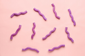 Hair curlers on pink background
