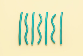 Hair curlers on yellow background