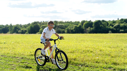 Fototapeta premium a boy rides a bike in the park
