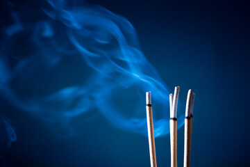 Incense sticks and incense stick smoke on black backgrond with white backlit
