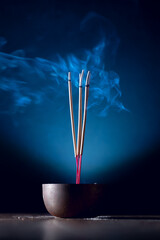 Incense sticks and incense stick smoke on black backgrond with white backlit