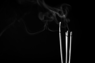 Incense sticks and incense stick smoke on black backgrond with white backlit