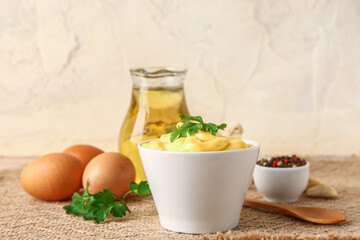 Bowl with tasty mayonnaise sauce on table
